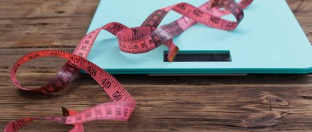 blue floor scales and pink tape on dark wooden backgroundの写真素材