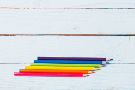 six-color rainbow from pencils on blue wooden backgroundの写真素材