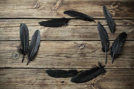black feather on old wooden backgroundの写真素材