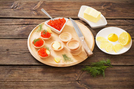 cooking tartlets with red caviar on wooden tableの写真素材