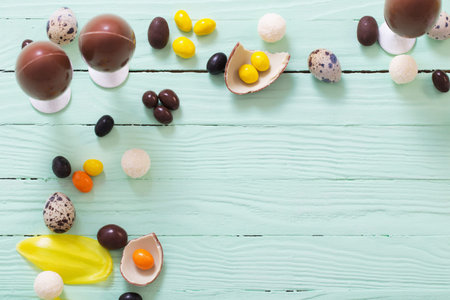 Easter chocolate eggs and candies on green wooden backgroundの写真素材