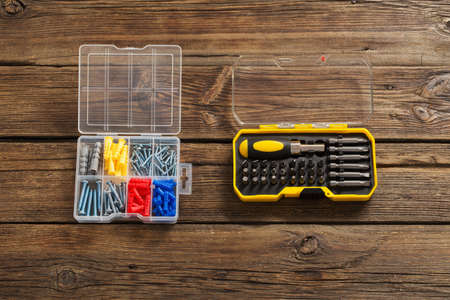 set of screwdrivers and screws on dark wooden backgroundの写真素材