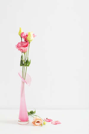 bouquet of eustoma in pink glass vase on white backgroundの写真素材