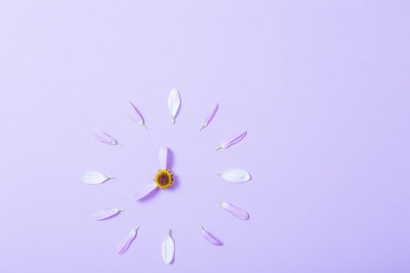 abstract clock made of flower petals on violet background