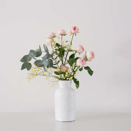 bouquet of pink roses in ceramic white vase on white backgroundの写真素材