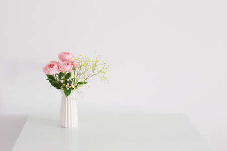 bouquet of pink roses in ceramic white vase on white backgroundの写真素材