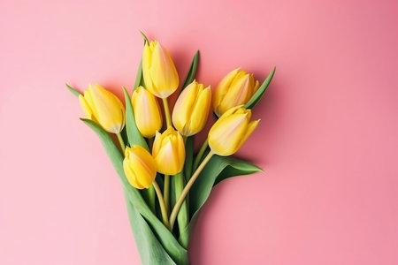 bouquet of yellow tulips on yellow background top viewの素材