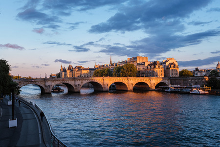 Paris, France - August 13, 2016. Sunset over Seine river, Pont Neuf bridge and Cite island with Royal palace, Conciergerie and medieval buildings. Evening Paris cityscape panoramic view.のeditorial素材
