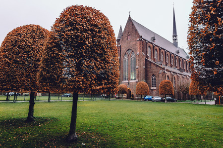 Ghent, Belgium - January 1th, 2017. Autumn park and church in New Saint Elisabeth beguinage in Sint-Amandsberg district, Gent. Known as Groot Begijnhof Sint-Amandsberg. Flanders World Heritage Site.のeditorial素材