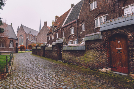 Ghent, Belgium - January 1th, 2017. New Saint Elisabeth beguinage in Sint-Amandsberg district. Groot Begijnhof Sint-Amandsberg. Brick belgium houses, cobbled street and wall by autumn in Gent.のeditorial素材