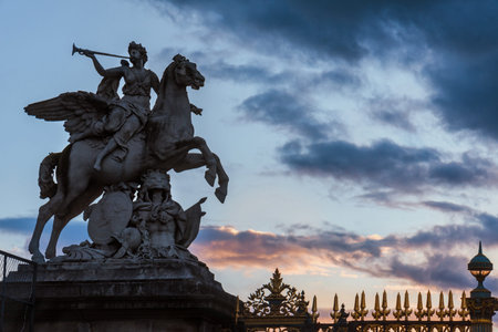 Paris, France - August 11, 2017. Statue of Renommee in the evening. Trumpeting Hermes and Pegasus at the entrance of Tuileries Garden. Old stone fame of the king sculpture in twilight.のeditorial素材