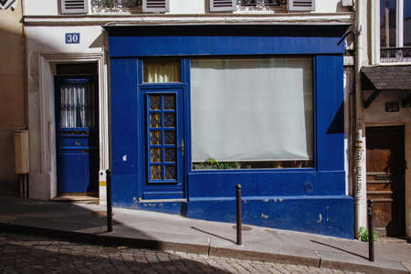 Paris, France - August 10, 2017. Old french house facade with colored wooden carved doors on Montmartre hill with no people. Paris picturesque antique front entry door, painted blue.のeditorial素材