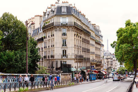 Paris, France - August 10, 2017. Parisian central street old house facade. Traditional architecture, authentic french architectural complex with people in front.のeditorial素材