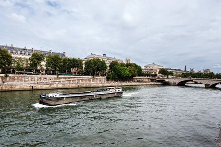 Paris, France - August 16, 2017. View of medieval Cite island and Pont au Change bridge from Seine riverside. Popular french landmark and tourist cruise boat in river Seine.のeditorial素材
