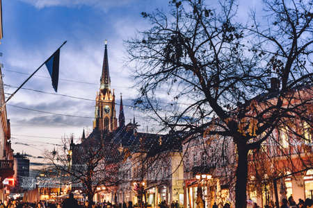 Novi Sad, Vojvodina, Serbia - February 1th, 2018. Holy Name of Mary church spire and Christmas Novi Sad Old town with festive lights and decorations during Winter festival by night.のeditorial素材