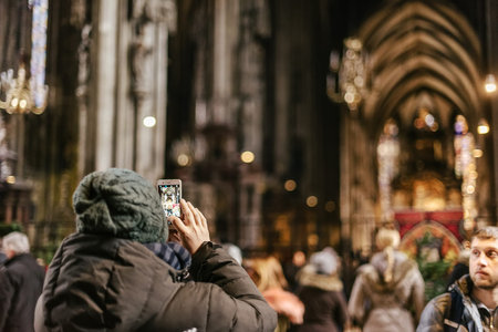 Vienna, Austria - December 30, 2017. Tourists taking picture using smartphone inside Saint Stephens...