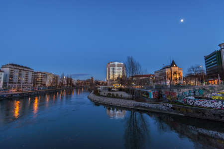 Vienna, Austria - December 29, 2017. Evening view of Wien river flows through the city of Vienna with lights and buildings reflected in water. Viennese embankment with graffiti and murals at dusk.のeditorial素材