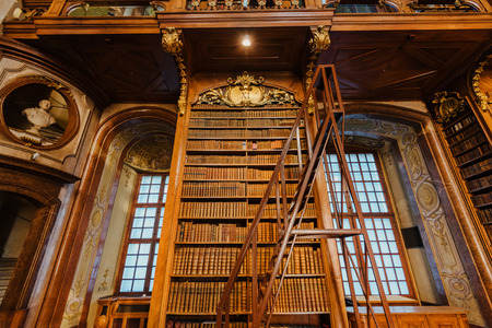 Vienna, Austria - December 24, 2017. Interior of Austrian National Library with wooden ladder and bookshelves. Hapsburg empires old baroque library hall with rare ancient folios and old maps.のeditorial素材