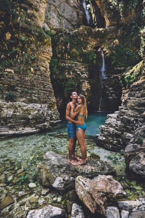 Young Couple in Hugging at Wild Waterfallの写真素材