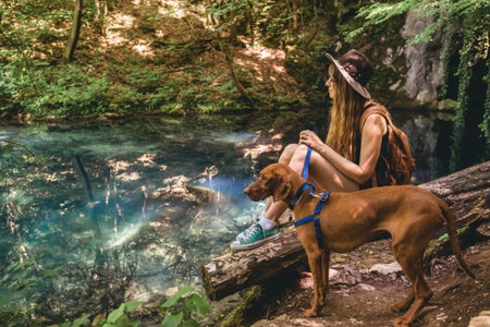 Woman Hiking in Mountain Forest with Dog