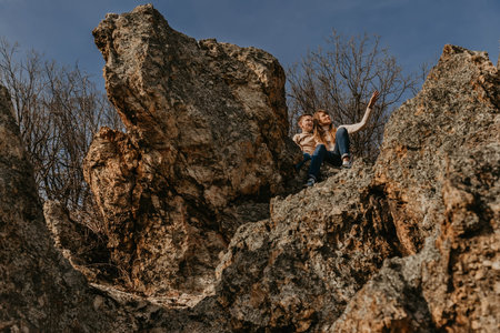 Mother and Son Sitting Together on Forest Rockの写真素材