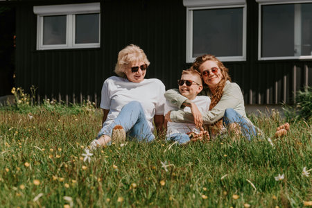 Grandmother with Adult Daughter and Grandson Relaxing Outdoorsの写真素材