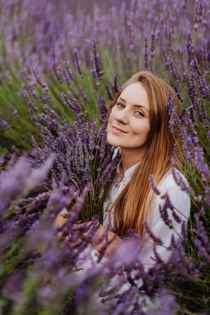 Woman Sitting among Rows of Lavender in Fieldの写真素材