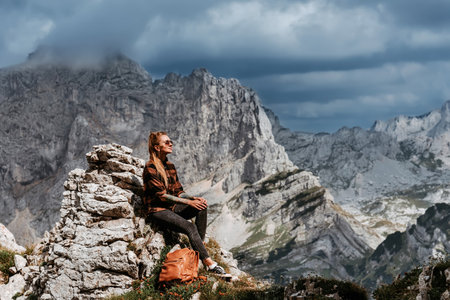 Woman Hiker Sitting on Rock in Mountain Landscapeの写真素材
