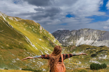 Woman Solo Travel Raised Hands in Mountainsの写真素材
