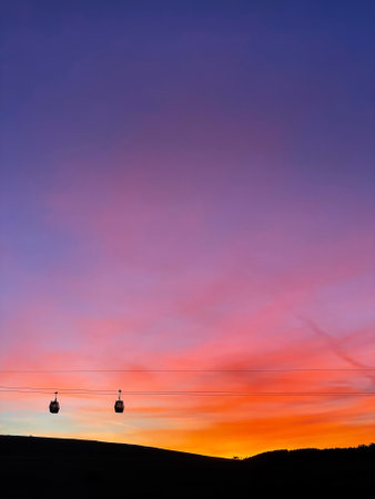 Two Gondola Cabins against Backdrop of Sunriseの写真素材