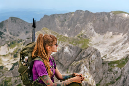 Woman Tourist with Backpack Sitting on Mountain Topの写真素材