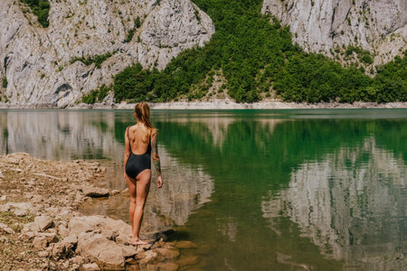 Woman in Swimsuit on Nature Background with Mountain Lakeの写真素材