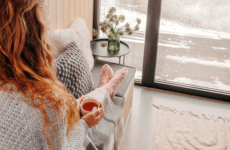 Woman Sitting with Cup of Tea on Winter Dayの写真素材