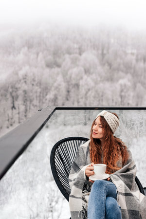 Woman Drinking Tea on House Terrace in Winterの写真素材
