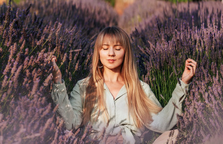 Woman Practicing Meditation and Breathing Exercises in Lavenderの写真素材