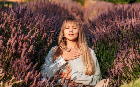 Woman Practicing Meditation and Breathing Exercises in Lavenderの写真素材