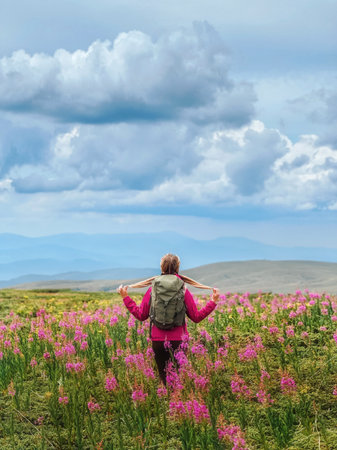 Woman Traveler in Meadow of Willowherb Flowersの写真素材