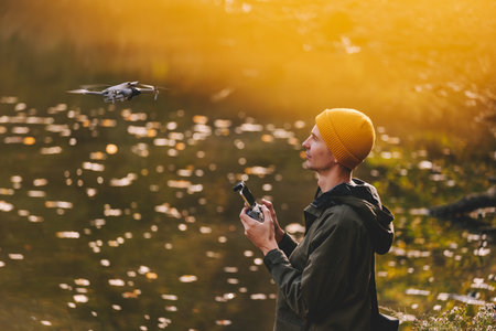 Man Flying Drone against Autumn Lakeの写真素材