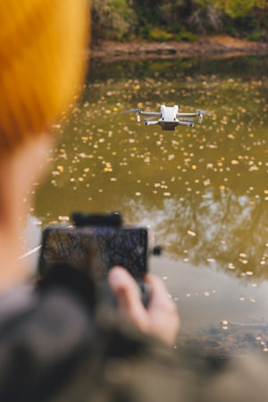 Person Flying Drone over Autumn Lakeの写真素材