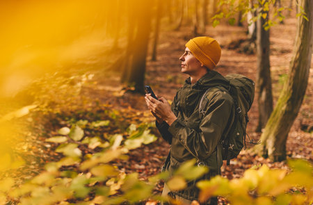 Man Hiker Using Smartphone for Navigation in Forestの写真素材