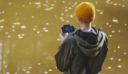 Man Filmmaker Viewing Camera Feed from Droneの写真素材