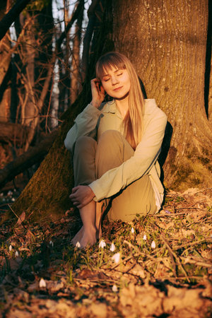 Young Woman with Eyes Closed in Spring Forestの写真素材