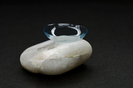 Contact lens on a piece of a granite-combination of fragility and hardness. の写真素材