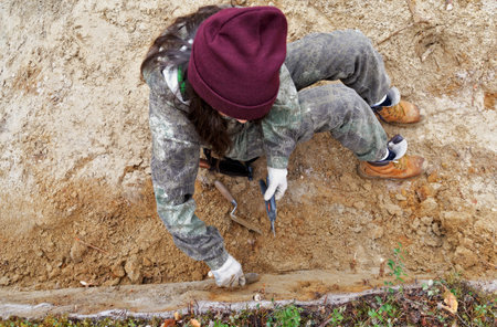 The girl-archaeologist of the excavation wall evensの写真素材