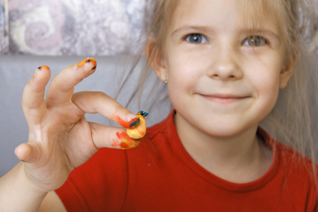 Girl shows a homemade painted crafts (focus on the hand) の写真素材