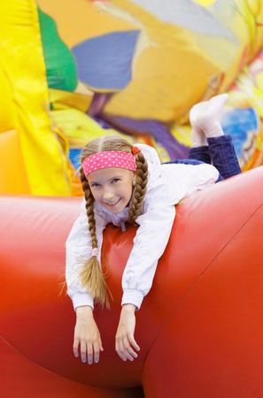 Girl have fun in the park on an inflatable attractionの写真素材