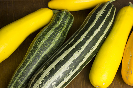 Several colorful courgettes lie on the tableの写真素材