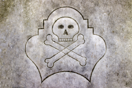 Skull and crossbones on a stone plateの写真素材