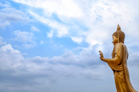 Buddha statue buddha image used as amulets of Buddhism religion in Thailand. Standing golden Buddha and the blue sky. (Top View)の写真素材