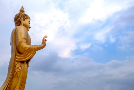 Buddha statue buddha image used as amulets of Buddhism religion in Thailand. Standing golden Buddha and the blue sky. (Top View)の写真素材